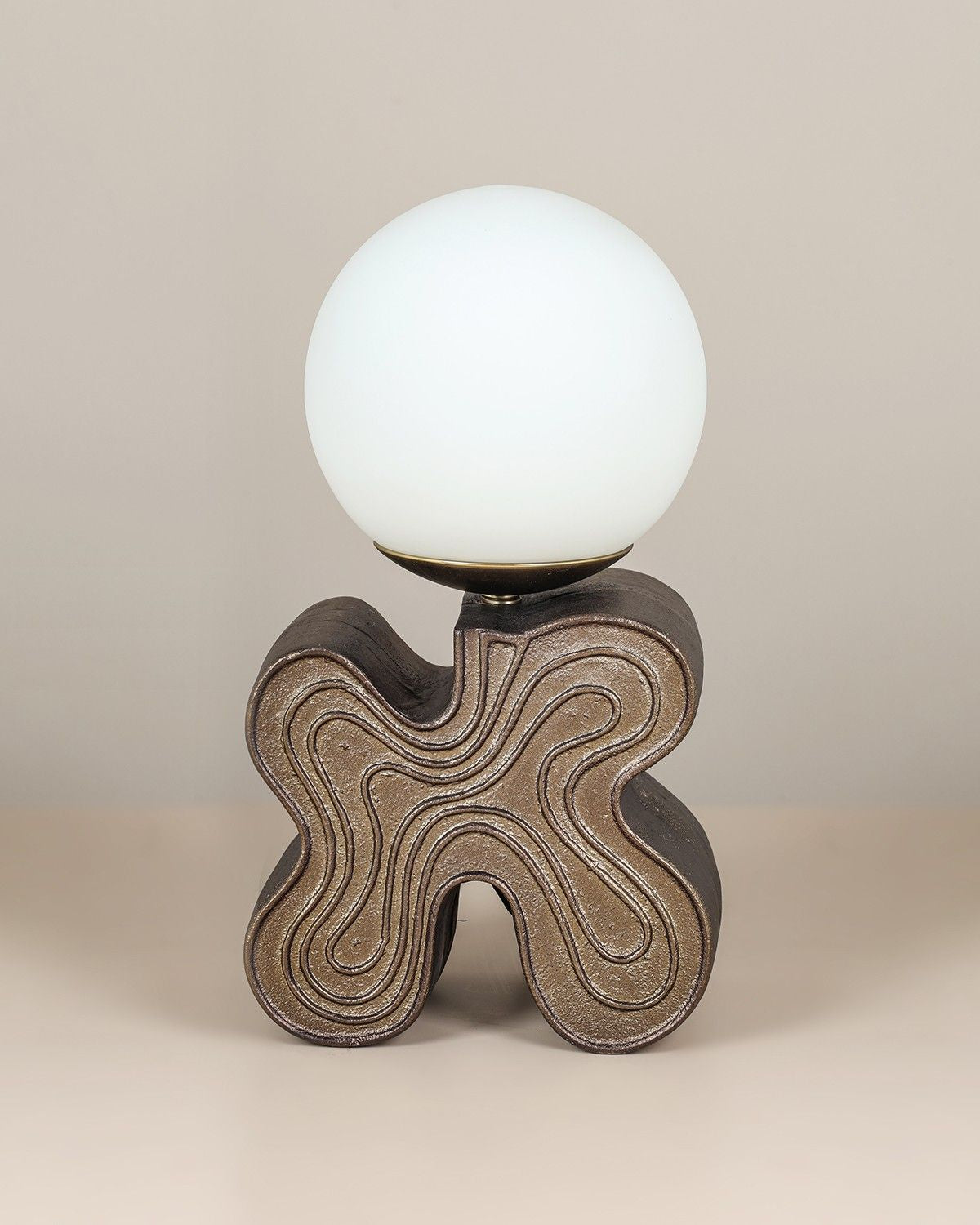 Eton Table Lamp with antique brass sculptural base and glass globe diffuser.