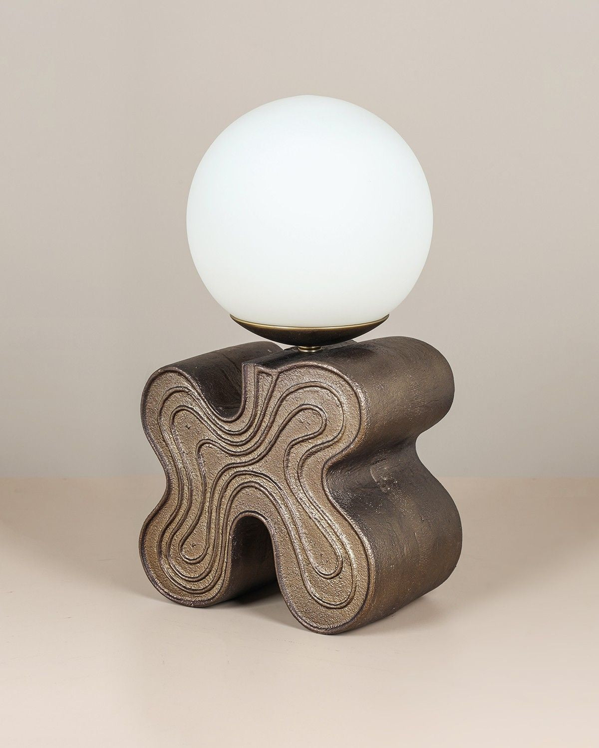 Eton Table Lamp with antique brass sculptural base and glass globe diffuser.