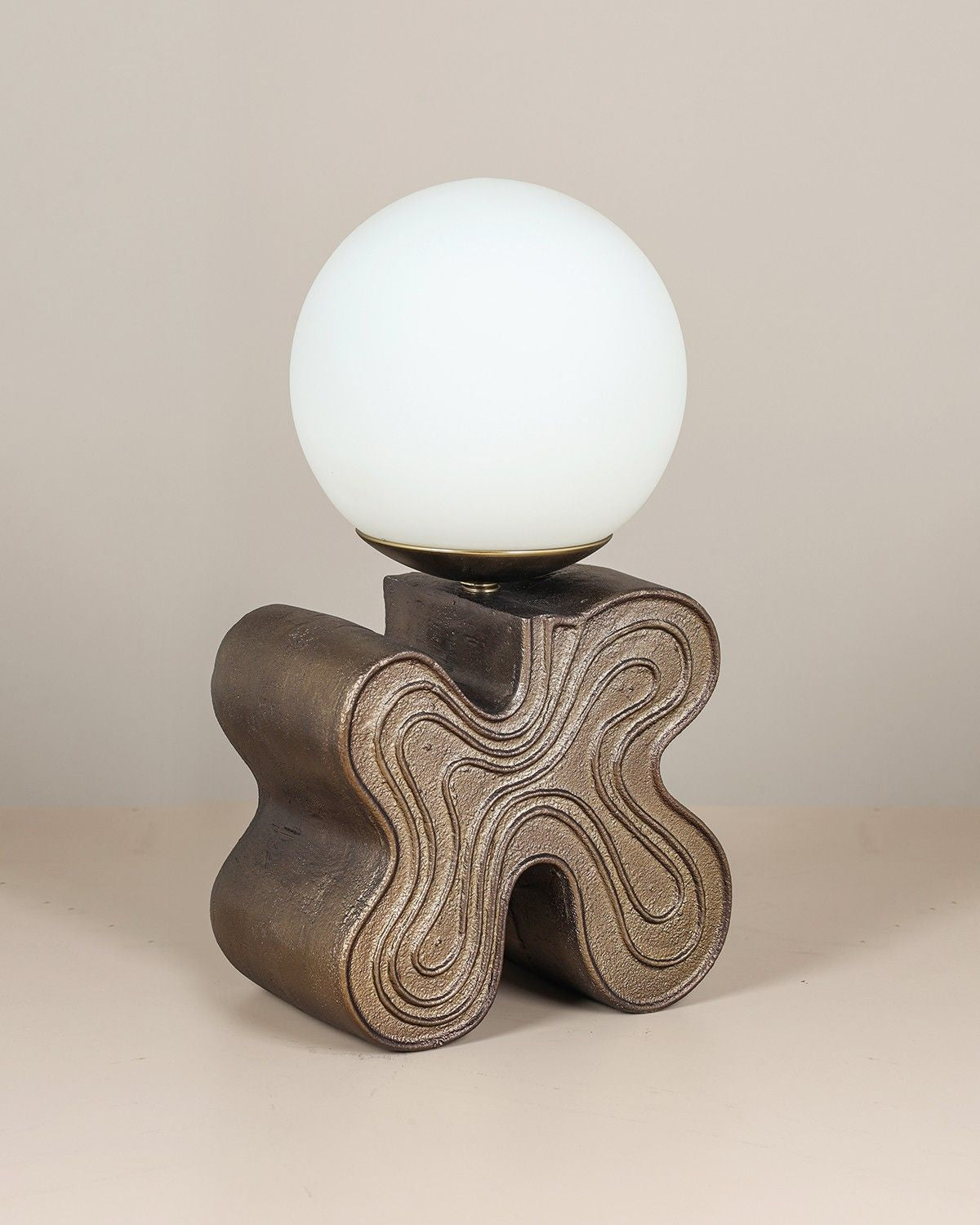Eton Table Lamp with antique brass sculptural base and glass globe diffuser.
