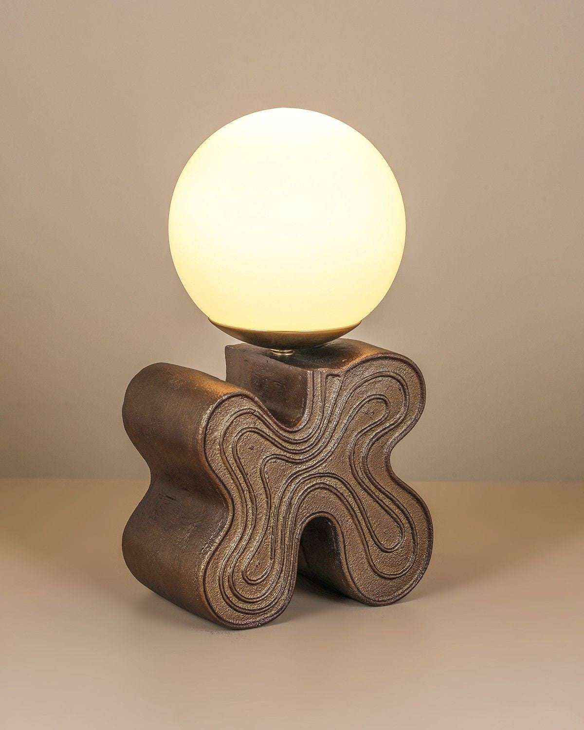 Eton Table Lamp with antique brass sculptural base and glass globe diffuser.